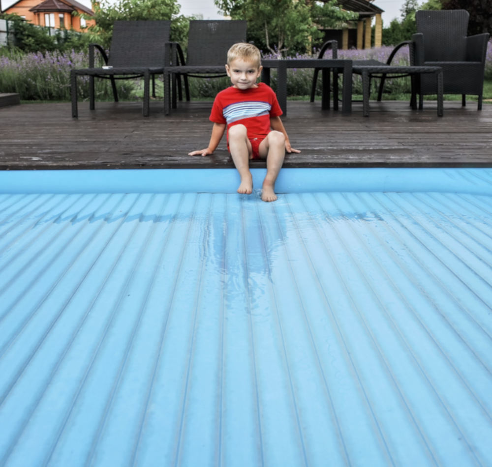 enfant sur couverture piscine